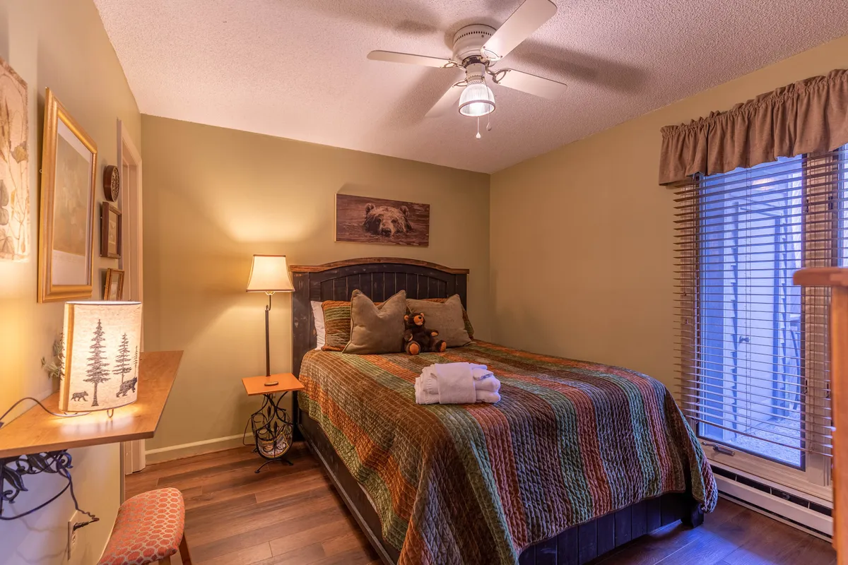 A cozy bedroom scene with a patterned quilt on the bed, a soft nightstand lamp casting a welcoming glow, and charming wall art creating a comfortable ambiance.