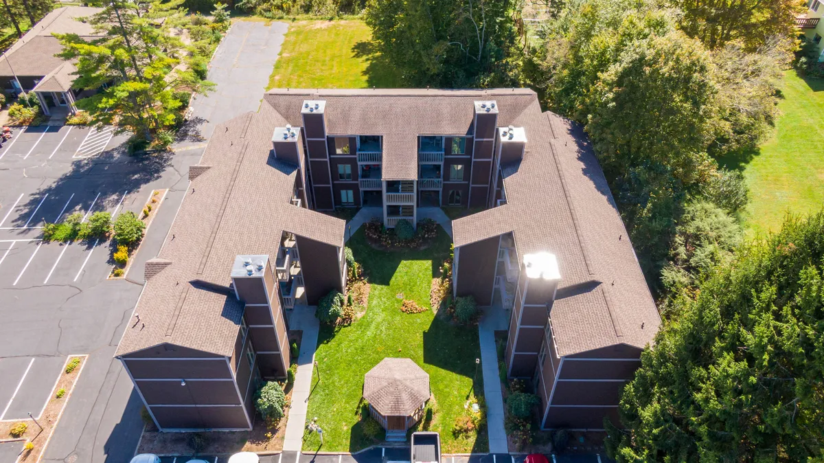 This scene captures a central green courtyard surrounded by residential buildings and landscaped gardens, with a charming gazebo at its center. It illustrates communal outdoor spaces ideal for relaxing, socializing, or enjoying the outdoors after a day exploring town.